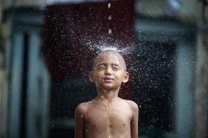 Buddhist novice monk Kyaw Thiha plays during heavy rainfall at Shin Ohtama Tharya monastery in Yangon